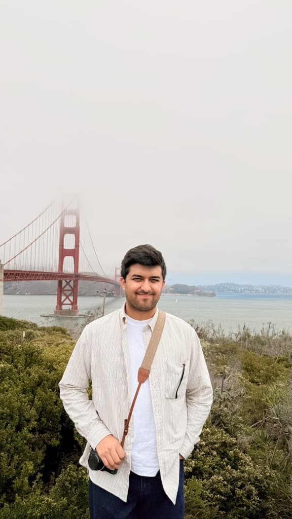 Arnav smiling in front of the Golden Gate Bridge